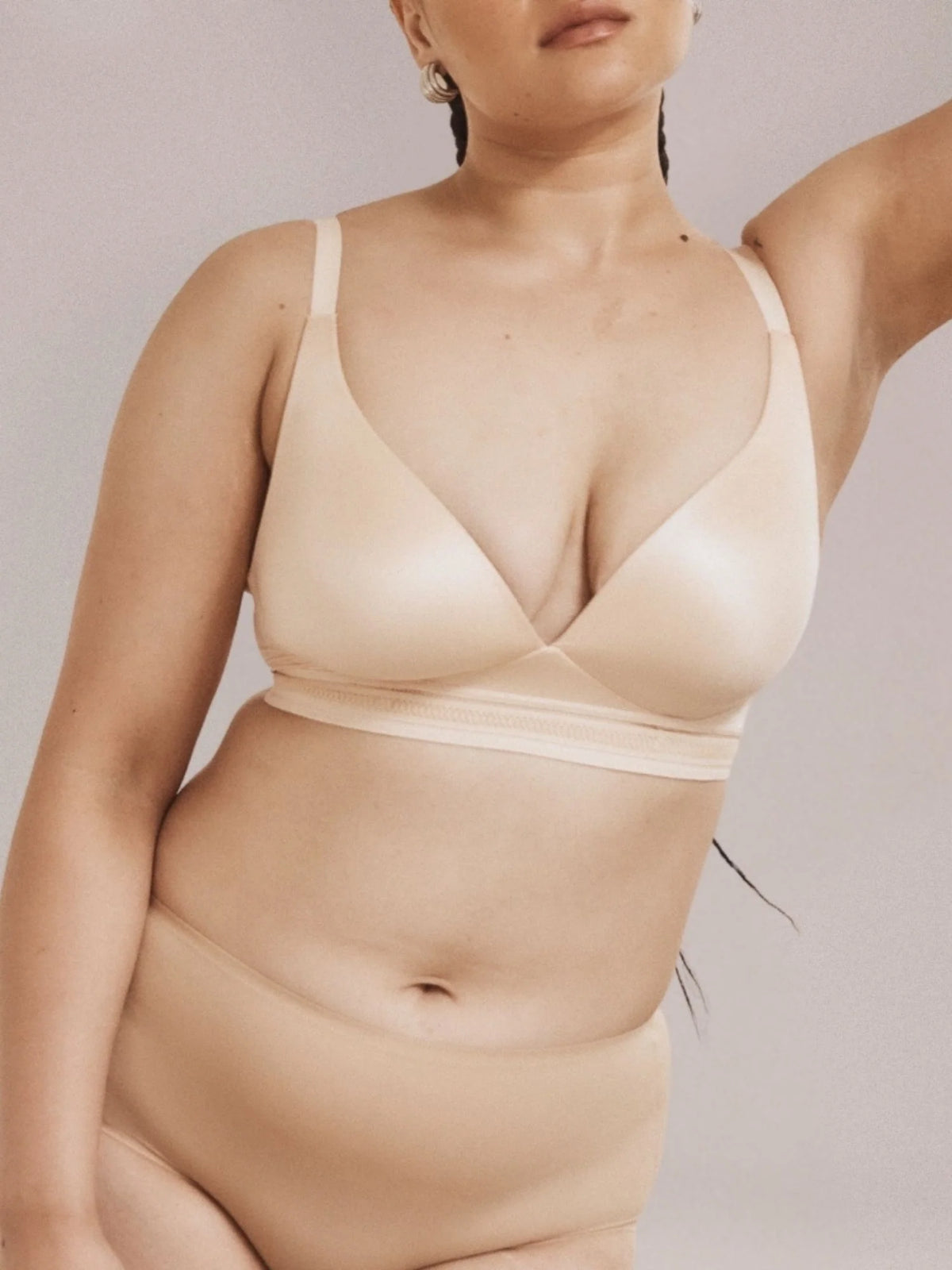 Woman wearing a beige wirefree bra and full brief set against a neutral background