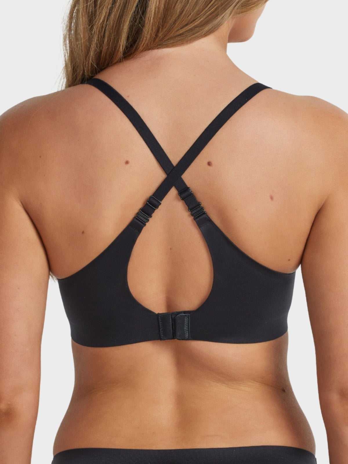 Ultrasoft Full Coverage T-Shirt Bra in Black worn with criss-cross straps, showing convertible back design