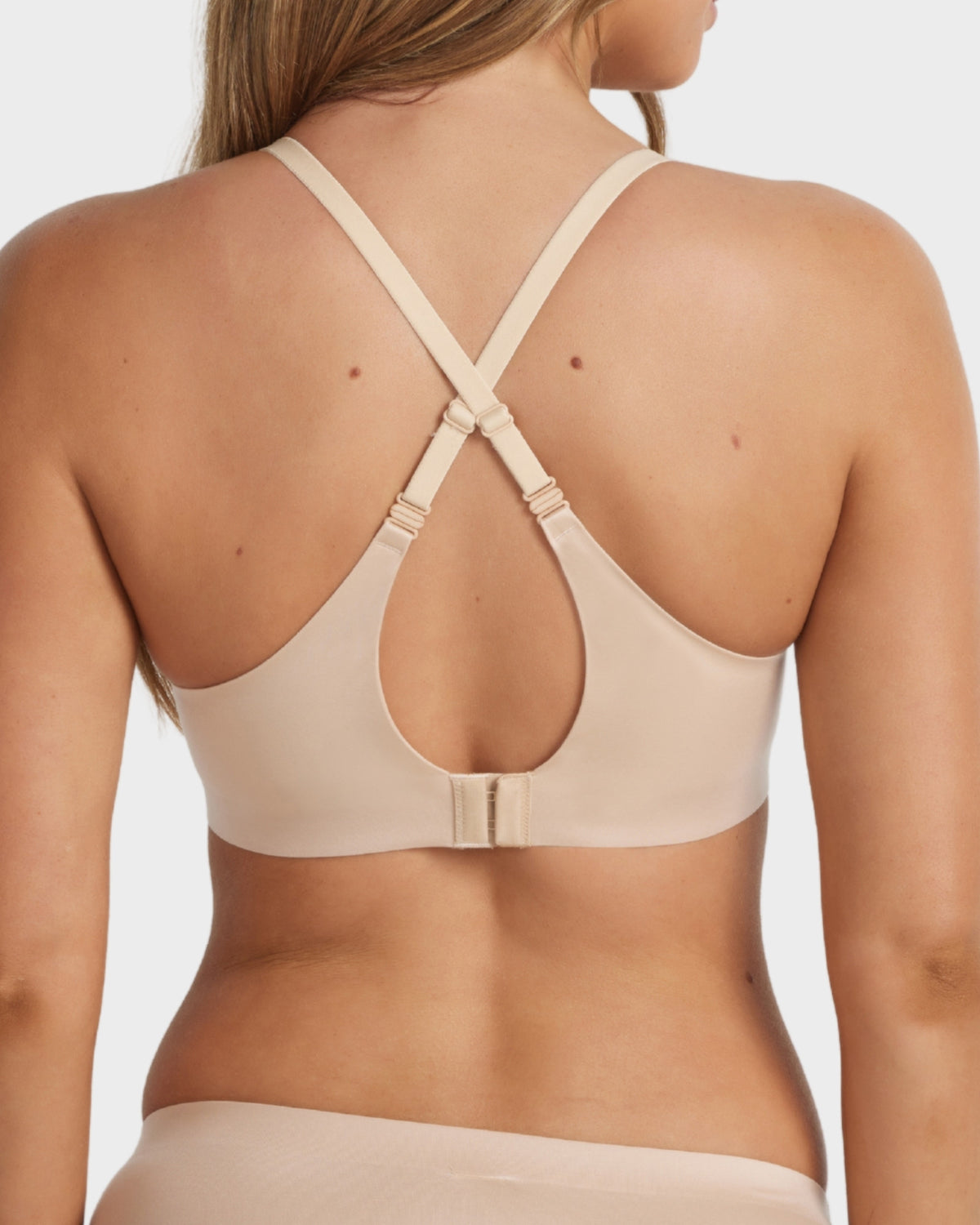 Beige neutral Ultrasoft Full Coverage T-Shirt Bra worn with criss-cross straps, highlighting the convertible back design