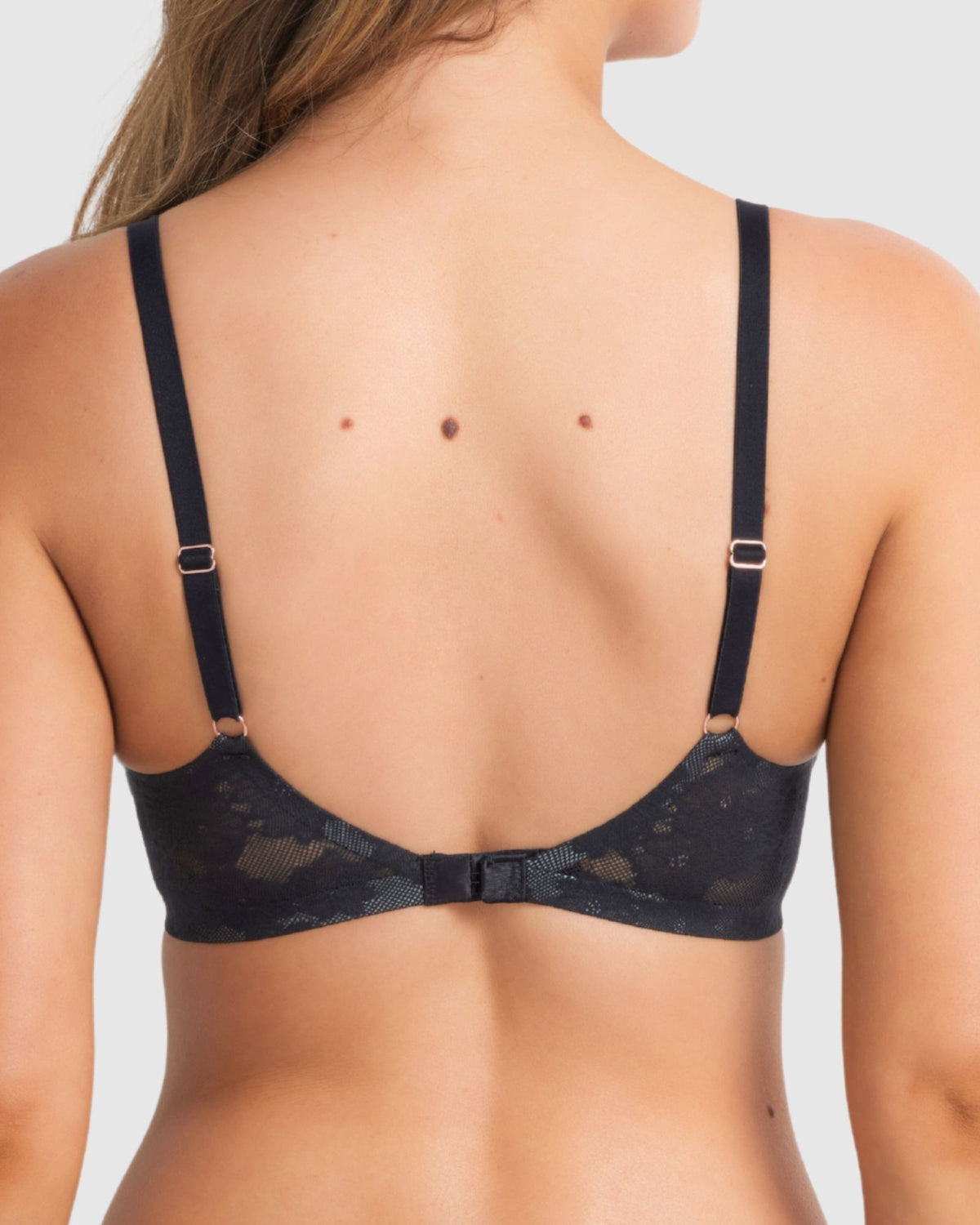 Back view of the black plunge bra worn by the model, featuring fully adjustable straps and hook-and-eye closure.