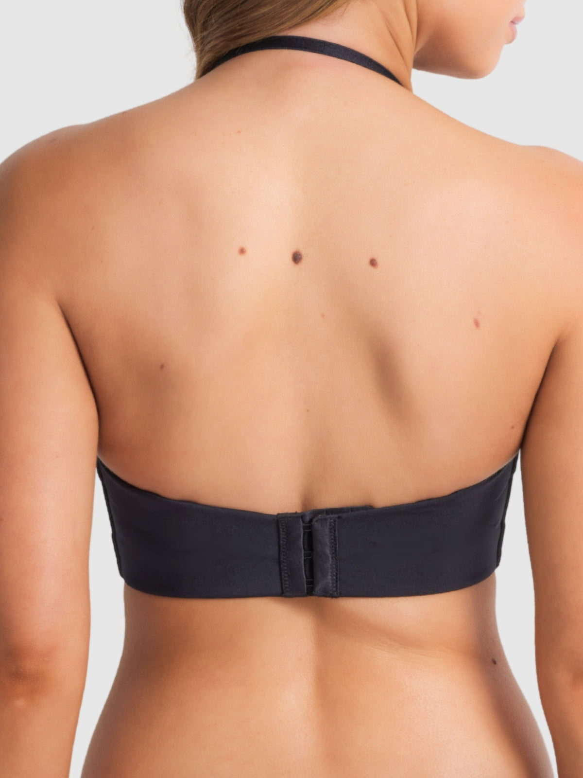 Black plunge bra worn halter-style with strap fastening behind the neck.