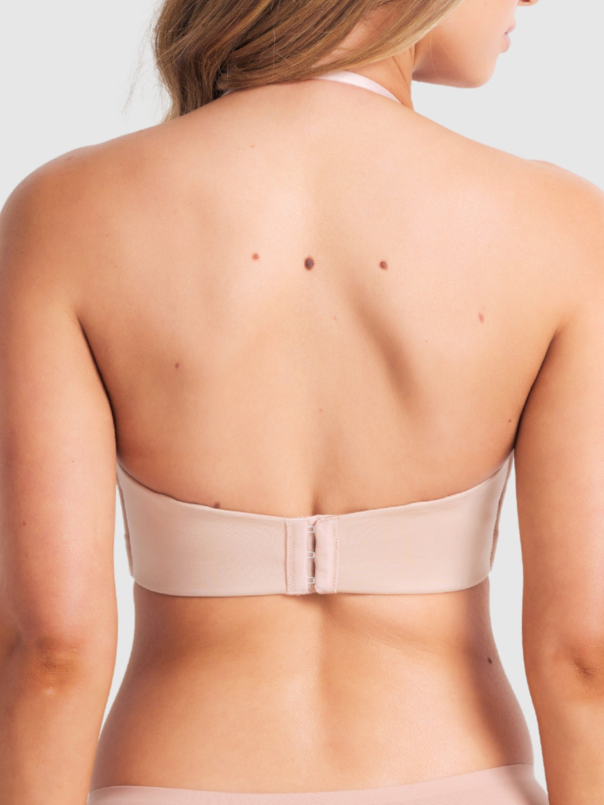 View of halter-style Caramel plunge bra with strap looping behind the neck.