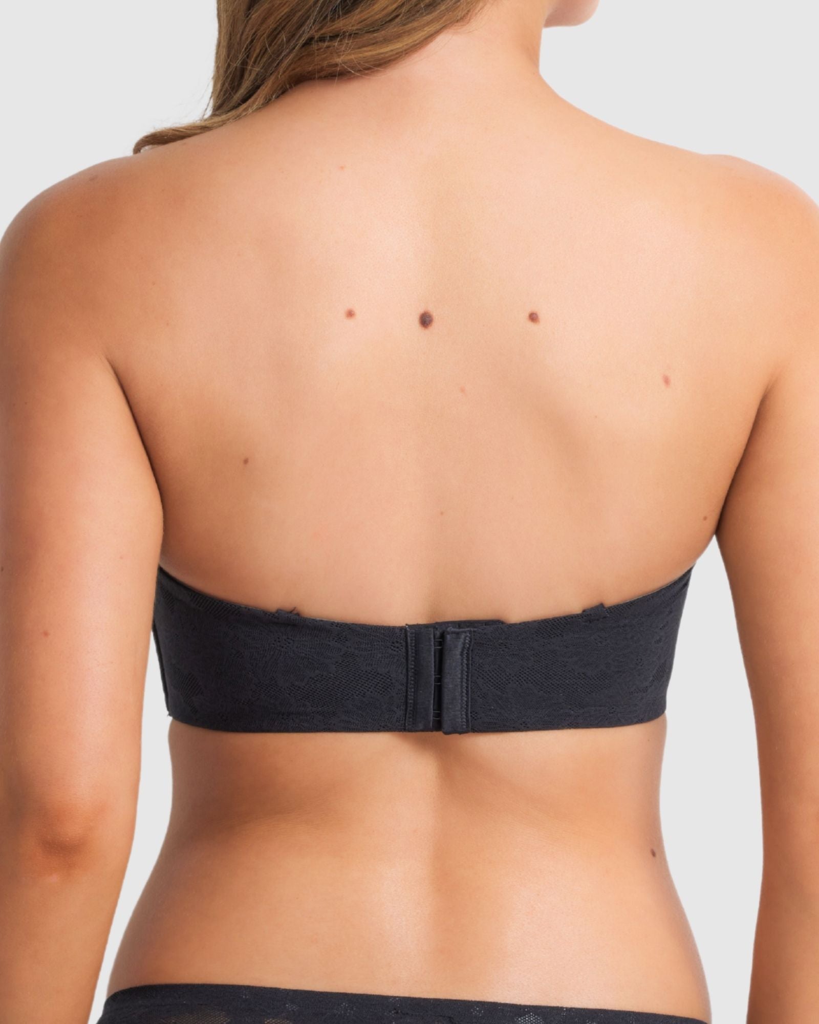 Model wearing the black strapless bra, emphasising secure support.