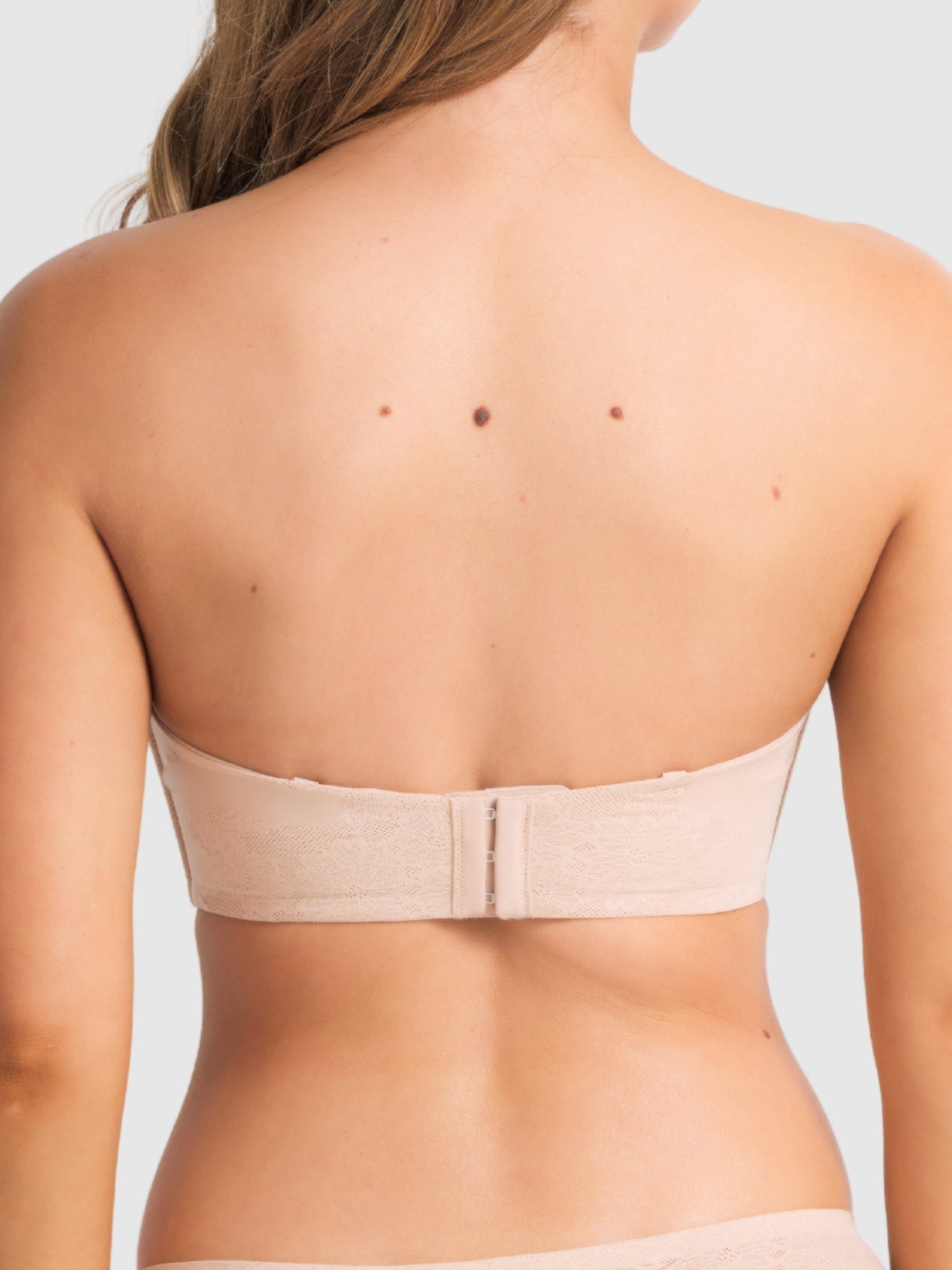 Model wearing the bra in strapless mode, focusing on secure fit and side boning support.