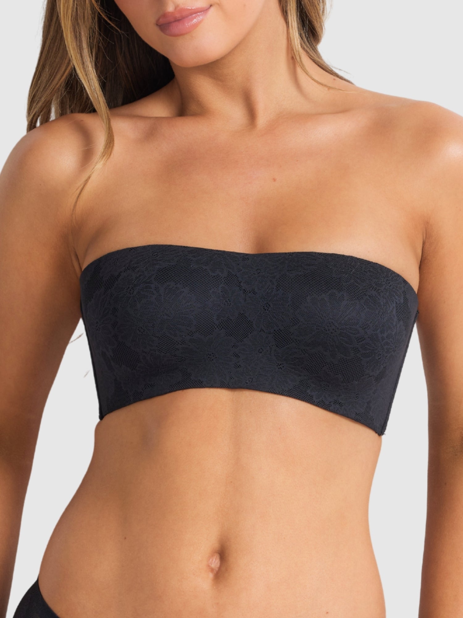 Model wearing the black strapless bra, emphasising secure support.