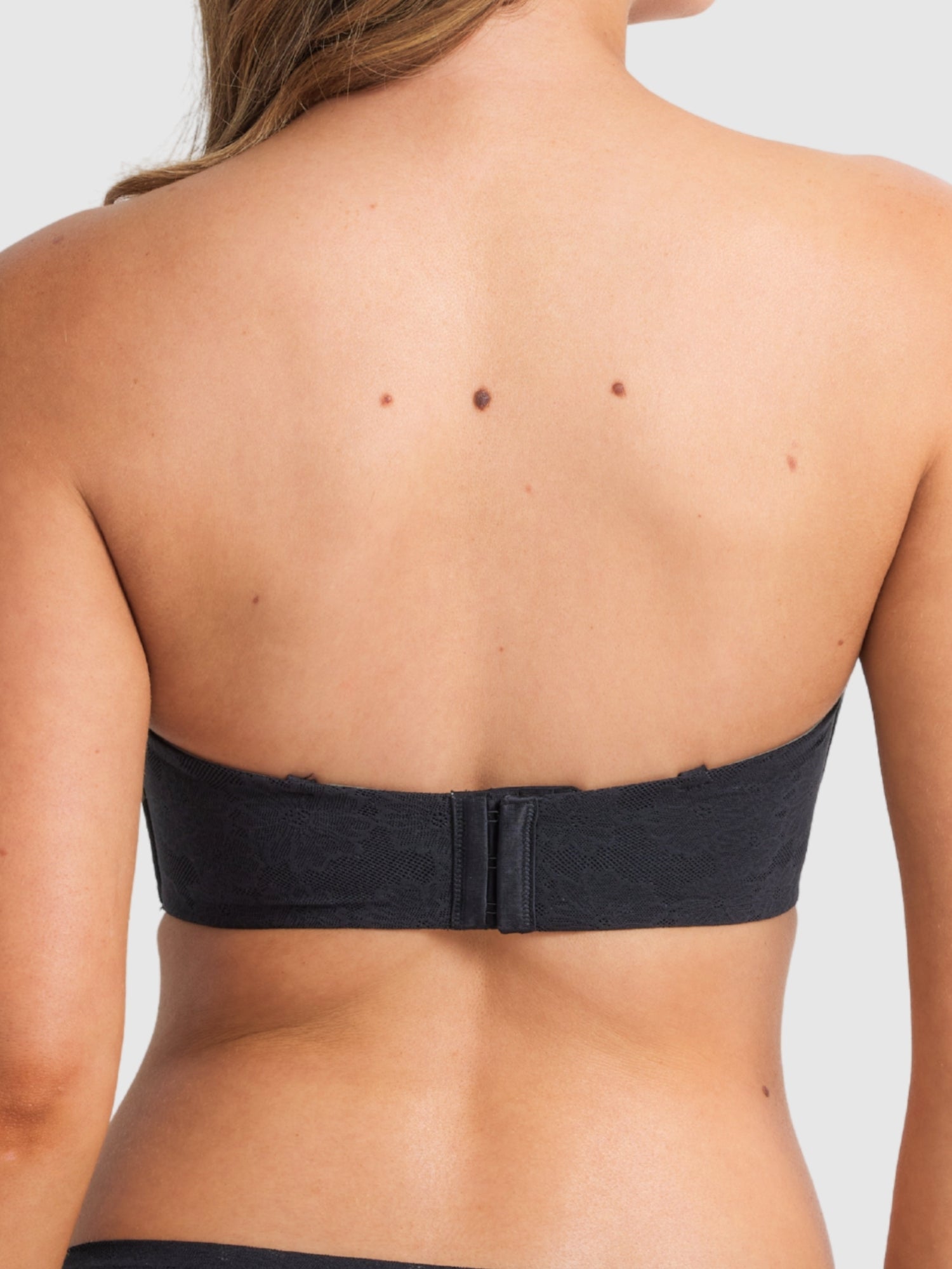 Model wearing the black strapless bra, emphasising secure support.
