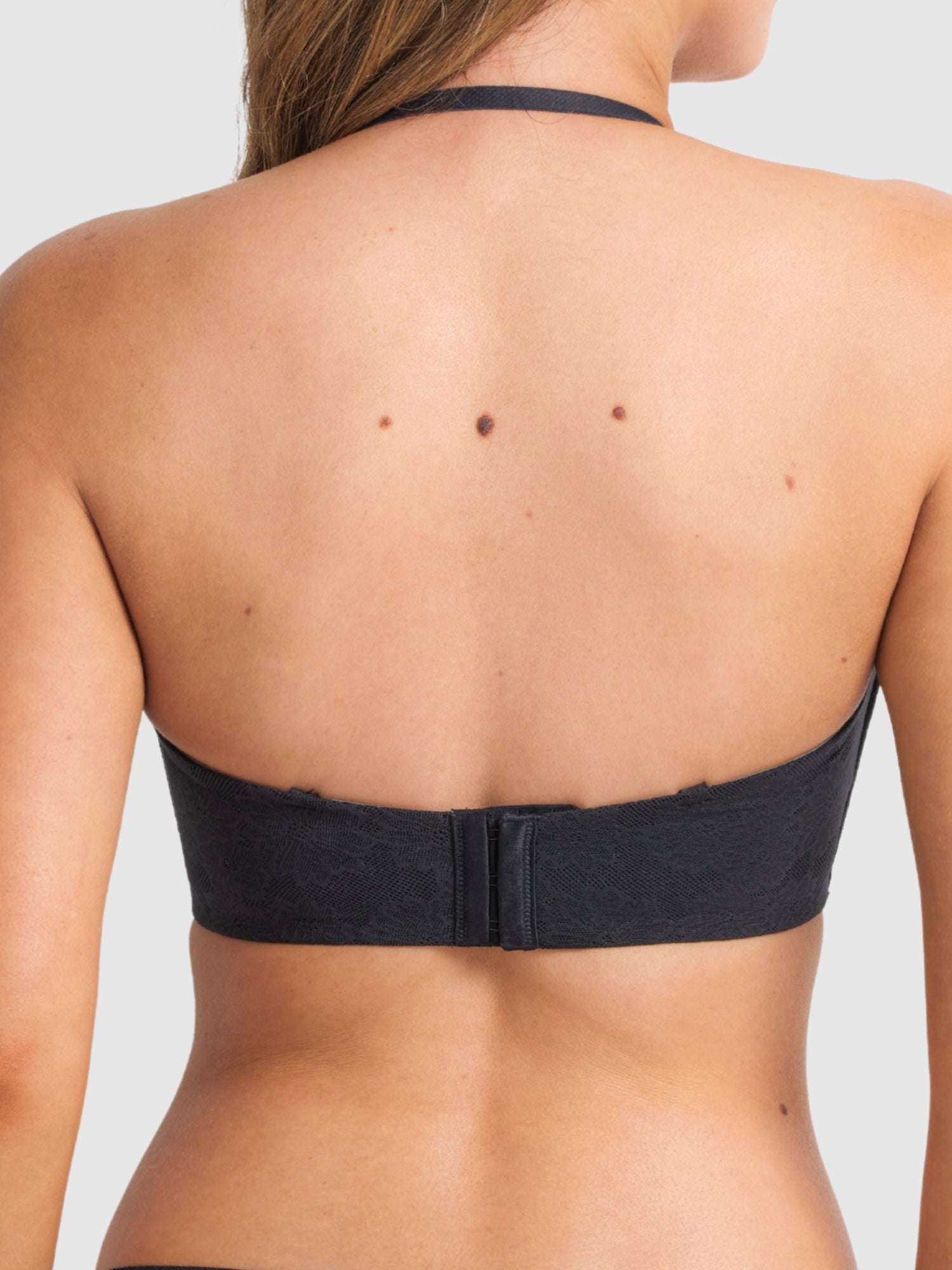 Model wearing the black strapless bra, emphasising secure support.