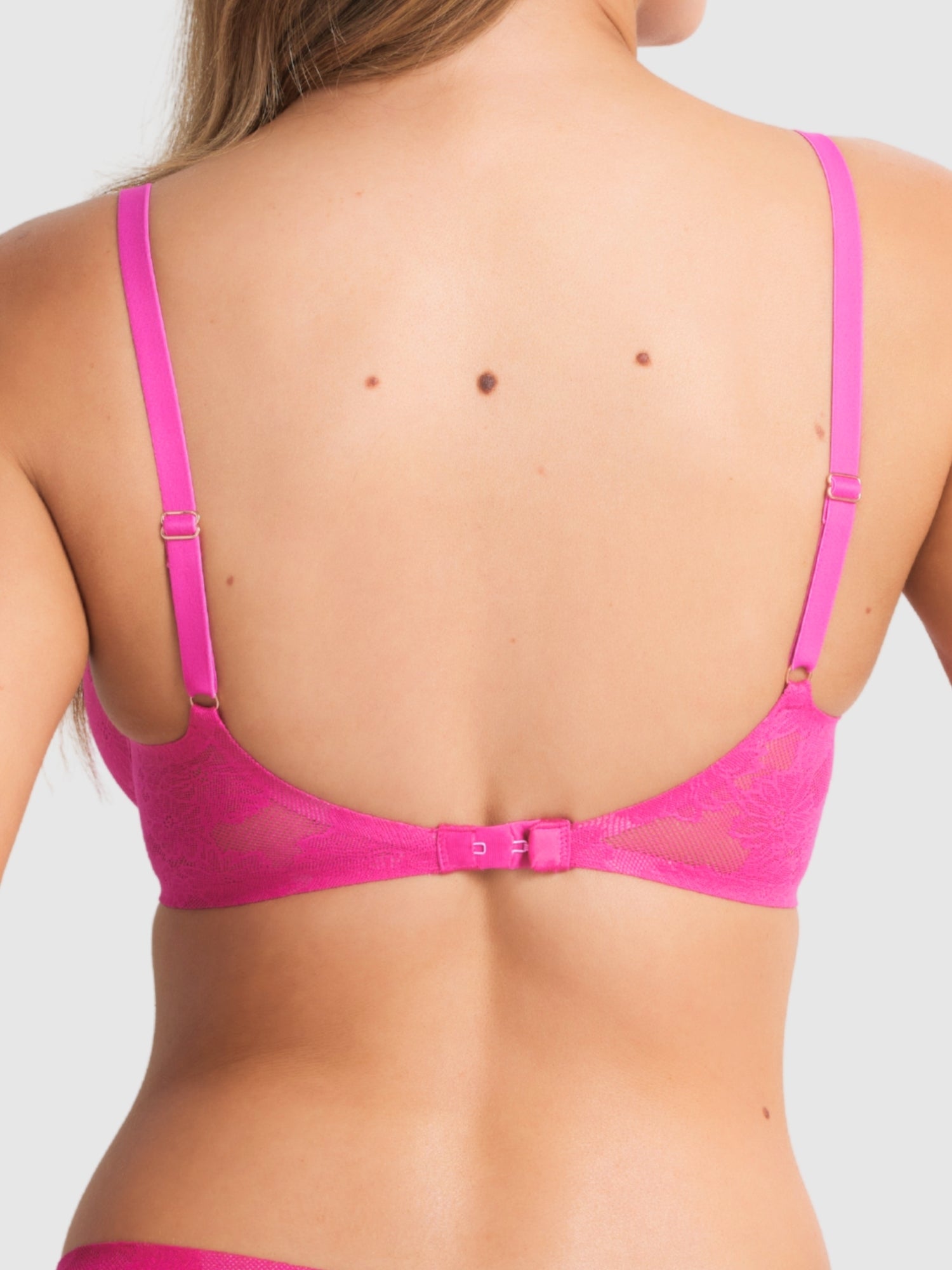 Model wearing the Weightless Underwire Lace Bra by Fine Lines Lingerie in Electric Fuschia, showing off the deep plunge neckline and floral lace design.